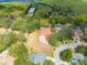 Aerial view of an estate featuring a red tiled roof, pool, and dock on the lake at 1654 Marina Lake Dr, Kissimmee, FL 34744