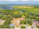 Wide aerial view displays a red-roofed home, surrounding trees, pool, and a waterfront dock providing lake access at 1654 Marina Lake Dr, Kissimmee, FL 34744