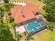 Aerial view of a single-Gathering home featuring a screened-in pool and a clay tile roof at 1654 Marina Lake Dr, Kissimmee, FL 34744