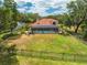 Spacious backyard featuring an enclosed pool and patio, surrounded by a black metal fence and lush trees at 1654 Marina Lake Dr, Kissimmee, FL 34744