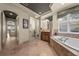 Luxurious primary bathroom with garden tub, separate vanities, and stone floors at 1654 Marina Lake Dr, Kissimmee, FL 34744