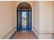 Elegant arched entryway with a blue leaded glass door and brick pavers at 1654 Marina Lake Dr, Kissimmee, FL 34744