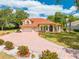 Stunning two-story home featuring a red tile roof, circular drive, lush landscaping, and a three-car garage at 1654 Marina Lake Dr, Kissimmee, FL 34744