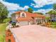 Mediterranean-style home boasts a clay tile roof, three-car garage, brick paver driveway and columns at 1654 Marina Lake Dr, Kissimmee, FL 34744