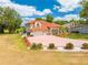 Mediterranean-style home with a clay tile roof, three-car garage, and a brick paver driveway and beautiful landscaping at 1654 Marina Lake Dr, Kissimmee, FL 34744