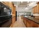 Bright kitchen featuring wood cabinets, granite countertops, a center island, and open layout to the dining area at 1654 Marina Lake Dr, Kissimmee, FL 34744