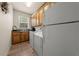 Functional laundry room features wooden cabinets, washer, dryer and bright window, perfect for efficient chores at 1654 Marina Lake Dr, Kissimmee, FL 34744