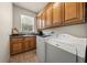 Functional laundry room with wooden cabinets, sink, and modern washer and dryer units at 1654 Marina Lake Dr, Kissimmee, FL 34744