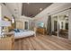 Spacious main bedroom featuring wood floors, tray ceiling, and sliding glass door to outdoor space at 1654 Marina Lake Dr, Kissimmee, FL 34744