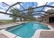 Sparkling pool and spa within a screened enclosure, surrounded by lush greenery at 1654 Marina Lake Dr, Kissimmee, FL 34744