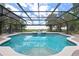 Large screened pool with a hot tub is surrounded by a brick deck and overlooks the yard at 1654 Marina Lake Dr, Kissimmee, FL 34744