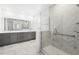 Bright bathroom featuring a double vanity with gray cabinetry and a glass enclosed shower with marble tile at 1850 Treasure Cv, Celebration, FL 34747