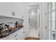 A hallway leading to the bathroom with marble tile and vanity with a granite countertop at 1850 Treasure Cv, Celebration, FL 34747