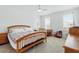 Bright bedroom with a wooden-frame bed, neutral-toned walls, two windows with blinds and a ceiling fan at 1850 Treasure Cv, Celebration, FL 34747