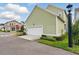 Exterior of garage with green siding, white door, and professional landscaping at 1850 Treasure Cv, Celebration, FL 34747