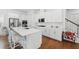 Well-lit kitchen features hardwood floors, a center island, and a staircase offering convenience at 1850 Treasure Cv, Celebration, FL 34747