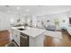 Open concept living area with kitchen island, dining table, large windows, and hardwood floors at 1850 Treasure Cv, Celebration, FL 34747