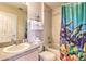 Functional bathroom features a tub with shower, a decorative curtain, and a single sink vanity at 214 Tupelo Cir, Davenport, FL 33897