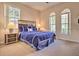 Cozy bedroom with a large window, queen bed and wooden nightstands with lamps at 214 Tupelo Cir, Davenport, FL 33897