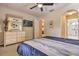 A serene bedroom featuring a dresser with mirror, a flat-screen TV, and a ceiling fan at 214 Tupelo Cir, Davenport, FL 33897