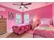 Themed pink bedroom featuring two beds, decorative artwork, and bright, playful ambiance at 214 Tupelo Cir, Davenport, FL 33897