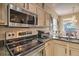 Close-up of a functional kitchen featuring stainless steel appliances and ample counter space at 214 Tupelo Cir, Davenport, FL 33897