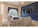 Cozy living room with a large sofa, blue accent wall, and a view to the pool area at 214 Tupelo Cir, Davenport, FL 33897