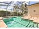 Sparkling pool and jacuzzi within a screened enclosure, providing a private and refreshing oasis for relaxation at 214 Tupelo Cir, Davenport, FL 33897