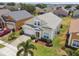 Well-manicured lawn, landscaped shrubbery, and a brick driveway accent this cream-colored home at 223 Cadiz Loop, Davenport, FL 33837