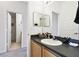Bathroom with a wooden vanity, an oval sink, two mirrors, and a view into the toilet room at 223 Cadiz Loop, Davenport, FL 33837