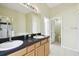 Bathroom featuring double sinks, black countertops and a separate shower, combining elegance and functionality at 223 Cadiz Loop, Davenport, FL 33837