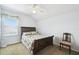 Well-lit bedroom with a wooden bed frame, ceiling fan, and window with lace valance at 223 Cadiz Loop, Davenport, FL 33837