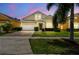 Charming two-story home featuring a manicured lawn, paver driveway, and attached two-car garage at 223 Cadiz Loop, Davenport, FL 33837