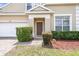 Well-maintained front exterior with a brick walkway, manicured bushes, and a two-car garage at 223 Cadiz Loop, Davenport, FL 33837