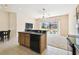 Spacious kitchen with wood cabinets, black dishwasher, and open floorplan leading to backyard at 223 Cadiz Loop, Davenport, FL 33837