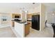 Open kitchen with updated black appliances, light wood cabinets, and an eat-in counter space at 223 Cadiz Loop, Davenport, FL 33837