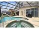 Screened-in pool and spa area featuring a built-in hot tub and relaxing patio furniture at 223 Cadiz Loop, Davenport, FL 33837