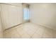 Bright bedroom featuring tiled floors, a window, and closet with folding doors at 2330 Prime Cir # A, Kissimmee, FL 34746