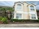 Beige two-story condo building featuring arched windows, manicured landscaping, and prominent address numbers at 2330 Prime Cir # A, Kissimmee, FL 34746