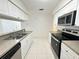 Bright kitchen with stainless steel appliances, double sinks, and white cabinets at 2330 Prime Cir # A, Kissimmee, FL 34746
