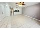 Spacious, open-concept living room with tile flooring and views into the kitchen at 2330 Prime Cir # A, Kissimmee, FL 34746