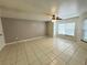 Open concept living room with tile floors, a ceiling fan, and large windows at 2330 Prime Cir # A, Kissimmee, FL 34746