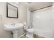 A bathroom features a pedestal sink, mirror and shower at 2411 Parsons Pond Cir, Kissimmee, FL 34743