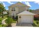 Charming two-story home with a one-car garage, manicured lawn, and vibrant landscaping at 2411 Parsons Pond Cir, Kissimmee, FL 34743