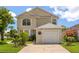 Charming two-story home with a one-car garage, manicured lawn, and vibrant landscaping at 2411 Parsons Pond Cir, Kissimmee, FL 34743