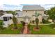 Inviting home featuring a well-kept lawn, symmetrical landscaping, and a charming brick walkway at 2411 Parsons Pond Cir, Kissimmee, FL 34743