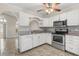 Bright kitchen features white cabinets, granite countertops, stainless steel appliances, and tile floors at 2411 Parsons Pond Cir, Kissimmee, FL 34743