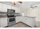 Bright kitchen features white cabinets, granite countertops, stainless steel appliances, and tile floors at 2411 Parsons Pond Cir, Kissimmee, FL 34743