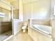 Spa-like bathroom featuring a soaking tub, a walk-in shower, and neutral tile at 2427 Continental Blvd, Orlando, FL 32808