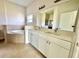 Bathroom featuring double sinks, a soaking tub, a walk-in shower, and neutral tile at 2427 Continental Blvd, Orlando, FL 32808